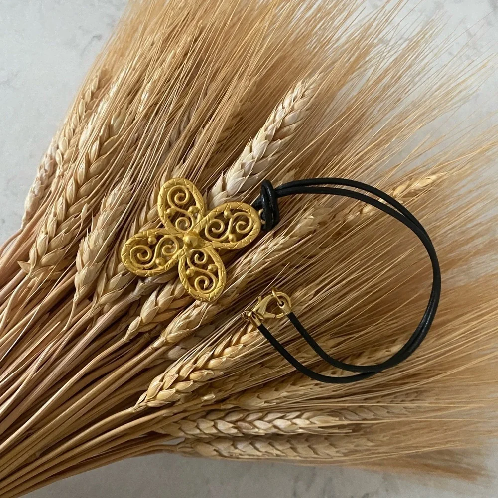 𝅺gold tone choker style necklace on leather cord